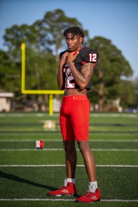 a black and red football player posing on a field