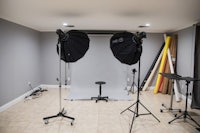 a photo studio with a light stand and a tripod