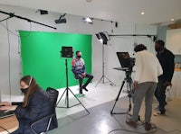 a group of people filming a video in a green screen studio